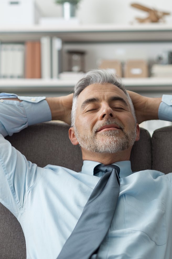 Uomo in cravatta rilassato sul divano